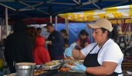 A cook prepares tacos at a street vending stand in the Pinata District in Downtown, Los Angeles, on March 23, 2019. AFP / Agustin Paullier