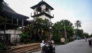 This October 3, 2019 photo shows a man driving his motorcycle past the ruins of a mosque in Kyaukphyu, Rakhine state, where Muslim residents have been forced to live in a camp for seven years after the inter-communal unrest tore apart the town. AFP / Ye A