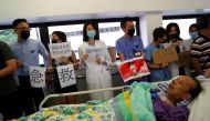 A patient is wheeled past as healthcare staff hold posters and participate in a human chain to protest against what they say is police brutality during the anti-extradition bill protests, at Queen Mary Hospital, in Hong Kong, September 2, 2019. Reuters/An