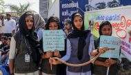 Students hold placards and a toy snake during a protest over the death of a girl after she was bitten by a snake inside her classroom at Sulthan Bathery in Wayanad's district in Kerala, India on November 22, 2019. AFP