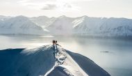  Skiers are dropped off by helicopter atop a mountain in Iceland.  Arctic Heli Skiing Iceland. 