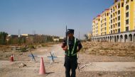 A Chinese police officer takes his position by the road near a vocational education centre in Yining in Xinjiang, Uighur Autonomous Region, China, September 4, 2018. Reuters / Thomas Peter