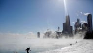 FILE PHOTO: A man keeps his balance as he walks on the edge of Lake Michigan's shore line as temperatures dropped to -20 degrees F (-29C) on January 30, 2019 in Chicago, Illinois.  AFP / Joshua Lott 