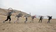 Young Afghan cyclists carry their bicycles on their back on a hill during an exercise on the outskirts of Kabul, Afghanistan, November 20, 2016. Reuters / Omar Sobhani