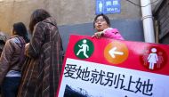 Women stand in line outside a men's toilet during a demonstration for more female sanitation facilities in Beijing, February 26, 2012. Reuters/China Daily