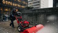 A building worker uses a snowblower to clear sidewalks in the Financial District as the first snowstorm of winter hits Manhattan on December 2, 2019 in New York. Scott Heins/Getty Images/AFP