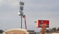 Several stores sits in front of a cell tower as Workers rebuild a cellular tower with 5G equipment for the Verizon network on November 26, 2019 in Orem, Utah. George Frey/Getty Images/AFP