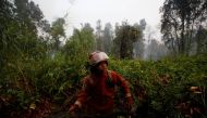 Bimpi Permata Restu, 18, who is a volunteer at Greenpeace's Forest Fire Prevention, holds a hose as he prepares to extinguish forest fires in Pulang Pisau regency near Palangka Raya, Central Kalimantan province, Indonesia, September 13, 2019. Reuters/Will