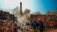 Firefighters extinguish the smoking bricks of an illegal brick factory being demolished following the decision of authorities from the Department Environment of the Ministry of Environment, Forest and Climate Change, on the outskirts of Dhaka on December 