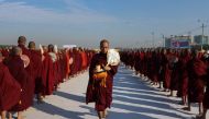 Monks line up for alms during the alms-giving ceremony to 30,000 monks organize by the region government of Mandalay affiliated with Dhammakaya Foundation at Chanmyathazi Airport in Mandalay on December 8, 2019.  / AFP / KYAW ZAY WIN
 