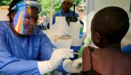 FILE PHOTO: A Ugandan health worker administers the Ebola vaccine to a child in Kirembo village, near the border with the Democratic Republic of Congo in Kasese district, Uganda, June 16, 2019. REUTERS/James Akena