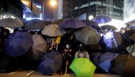 Protesters hide behind umbrellas during a Human Rights Day march, organised by the Civil Human Right Front, in Hong Kong, China December 8, 2019. Picture taken with a long exposure. REUTERS/Danish Siddiqui