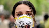 A demonstrator with a mask attends a climate protest rally in Sydney on December 11, 2019. Up to 20,000 protesters rallied in Sydney on December 11 demanding urgent climate action from Australia's government, as bushfire smoke choking the city caused heal