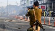 A security personnel fires tear gas during a curfew in Guwahati on December 12, 2019, following protests over Citizenship Amendment Bill -CAB.  AFP / Biju Boro
