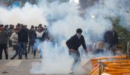 :FILE PHOTO: Protesters run for cover amid tear gas fired by police during a protest against the Citizenship Amendment Bill, a bill that seeks to give citizenship to religious minorities persecuted in neighbouring Muslim countries, outside the Jamia Milli