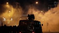 Lebanese riot police prepare to fire teargas canisters during clashes with anti-government demonstrators in the capital Beirut on December 14, 2019. / AFP / SERVICES AFP / ANWAR AMRO
