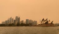 The haze from bushfires obscures the sun setting above the Sydney Opera House in Sydney, Australia, December 6, 2019. Reuters/John Mair
