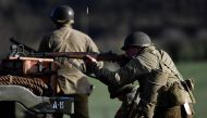 TOPSHOT - An actor wearing a WWII US uniform aims with his rifle as he takes part in a historical re-enactment of the Battle of the Ardennes as part of commemorations marking the 75th anniversary of the WWII battle, in Hardigny on December 15, 2019.  / AF