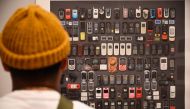 A visitor looks at a photo of cell phones confiscated from migrants at the exhibition 