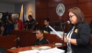 This handout from the Supreme Court - Public Information Office (SC-PIO) taken and released on December 19, 2019, shows a court employee (R) reading the verdict for the 2009 Maguindanao massacre at the trial venue inside a prison facility in Manila. AFP P