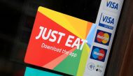 Signage for Just Eat is seen on the window of a restaurant in London, Britain, August 5, 2019. Reuters/Toby Melville