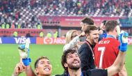Liverpool’s Brazilian midfielder Roberto Firmino (left) and goalkeeper Alisson Becker pose with the trophy.
