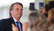 Brazil's President Jair Bolsonaro poses for pictures as he leaves the Alvorada Palace in Brasilia, Brazil December 12, 2019. REUTERS/Adriano Machado