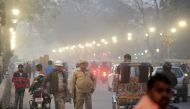 Indian policemen stand as traffic passes through the Civil Lines area of Allahabad on December 14, 2016. AFP / Sanjay Kanojia
 