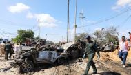 A Somali police officer walks past a wreckage at the scene of a car bomb explosion at a checkpoint in Mogadishu, Somalia December 28, 2019. REUTERS/Feisal Omar