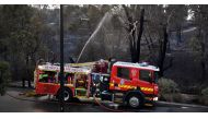 A fire truck dampens down a fire after a bushfire encroached on the outer suburbs of Melbourne. Australia. December 30, 2019 / AFP / William WEST

