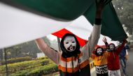 Demonstrators wearing masks hold a tricoloured flag in front of the India Gate during a demonstration against what they say was an alleged police action conducted during recent protests against a new citizenship law, in New Delhi, India, December 30, 2019