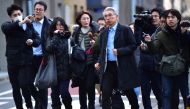 Members of the media surround Japanese lawyer for former auto tycoon Carlos Ghosn, Junichiro Hironaka (centre R), as he walks to his office in Tokyo on December 31, 2019.  AFP / Kazuhiro Nogi
 