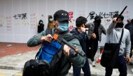 A plain-cloth police officer holds a weapon to disperse anti-government protesters during a demonstration on New Year's Day to call for better governance and democratic reforms in Hong Kong, China, January 1, 2020. Reuters/Tyrone Siu