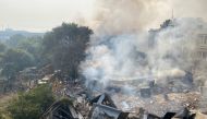  Smoke rises over the debris of a building that collapsed, as rescue workers (L) gather nearby, in New Delhi on January 2, 2020. / AFP / Atish PATEL