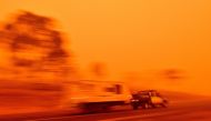 Residents commute on a road through thick smoke from bushfires in Bemboka, in Australia's New South Wales state on January 5, 2020. AFP / SAEED KHAN