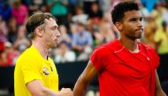 John Millman of Australia (L) shakes hands with Felix Auger-Aliassime of Canada (R) following his victory in their men's singles match on day three of the ATP Cup tennis tournament in Brisbane on January 5, 2020./ AFP / AFP / Patrick HAMILTON /