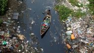 FILE PHOTO: A man on a boat collects plastic materials from dirty water in Dhaka, Bangladesh, April 17, 2019. REUTERS/Mohammad Ponir Hossain
