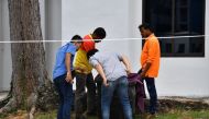 Police officers and cleaners inspect the contents of a bin at a rubbish chute, after a baby was found alive among rubbish in a bin at a public housing estate in Singapore, January 7, 2020. Lim Yaohui/The Straits Times via REUTERS