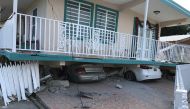 Cars lie under a collapsed house after an earthquake in Guanica, Puerto Rico January 6, 2020. REUTERS/Ricardo Ortiz