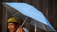 A street vendor uses an umbrella as he waits for customers at a traditional market in Jakarta, Indonesia, June 3, 2019. Reuters / Willy Kurniawan