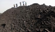 Workers walk on a heap of coal at a stockyard of an underground coal mine in the Mahanadi coal fields at Dera near Talcher town in Orissa state, India March 28, 2012. Reuters / Rupak De Chowdhuri