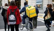 (FILES) In this file photo taken on December 03, 2019, a worker of Glovo, rides his bike during a delivery, on December 3, 2019 in Barcelona. AFP / PAU BARRENA