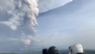 People take photos of a phreatic explosion from the Taal volcano as seen from the town of Tagaytay in Cavite province, southwest of Manila, on January 12, 2020. AFP / Bullit Marquez 