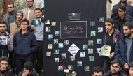 Iranian students hold pictures of victims during a memorial for the passengers of the Ukraine plane crash, in University of Tehran on January 14, 2020.   AFP / ATTA KENARE
