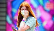 A woman holds onto her face mask during a practice session in Melbourne on January 15, 2020, ahead of the Australian Open tennis tournament. AFP / Asanka Brendon Ratnayake