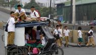 Children sit on top of a tricycle cab as they make their way to school along a main street in Tondo city, metro Manila June 4, 2012. Reuters/Romeo Ranoco