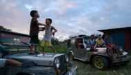Children displaced by the Taal volcano eruption play on vehicles at a government complex used as an evacuation centre in Tagaytay on January 18, 2020. / AFP / Ed JONES