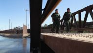 US Border Patrol agents walk over a canal of water flowing into Mexico at the US Mexico border fence on November 17, 2016 in San Luis, Arizona. John Moore / Getty Images / AFP