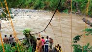 Locals and rescue workers stand on the remains of a footbridge that collapsed following heavy rains as they search for the missing in Kaur regency, Bengkulu province, Indonesia, January 20, 2020 in this photo taken by Antara Foto. Picture taken January 20