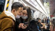 Subway passengers wear protective masks in Beijing on January 21, 2020. AFP / NOEL CELIS